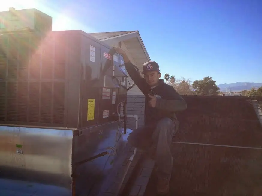HVAC technician performing AC Tune-Up on a rooftop unit in Southlake